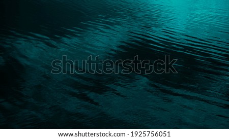   Dark blue green abstract background. Reflection of light on a smooth surface of water with small waves. Tidewater green background with copy space for design. Web banner.           Royalty-Free Stock Photo #1925756051