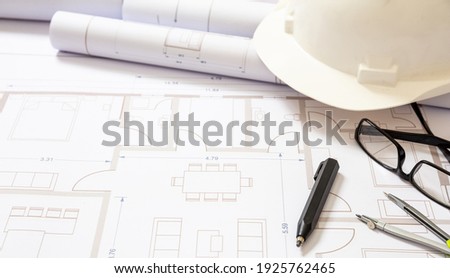 Project blueprints and engineer hardhat white color on drawings background. Housing project construction, architect site office concept.