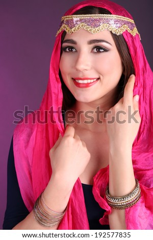 Beautiful oriental girl on dark colorful background