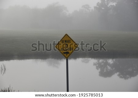 alligator sign in park on foggy morning