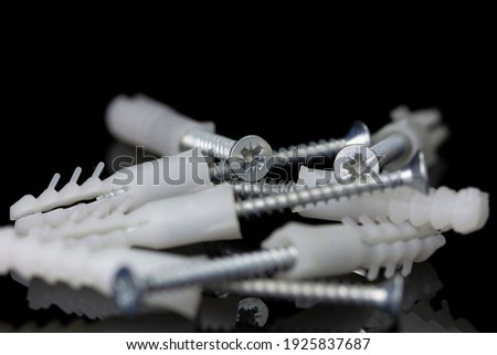 Macro shot of screws and pins on black mirror