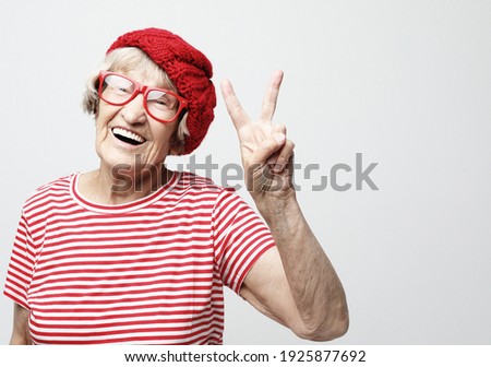 Old woman laugh and showing peace or victory signat camera. Emotion and feelings. Portrait of expressive grandmother.Close up.