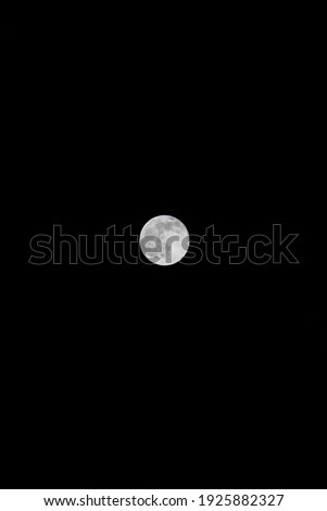 Beautiful full moon among dark background. Photo was taken from window. Perfect contrast colors are on the picture