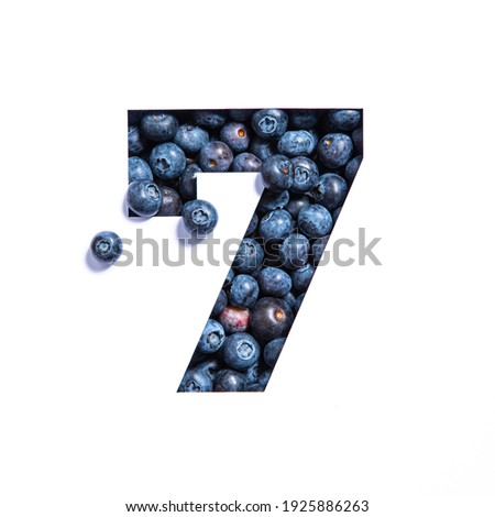 Number seven made of blueberries and paper cut in shape of seventh numeral isolated on white. Bilberry typeface