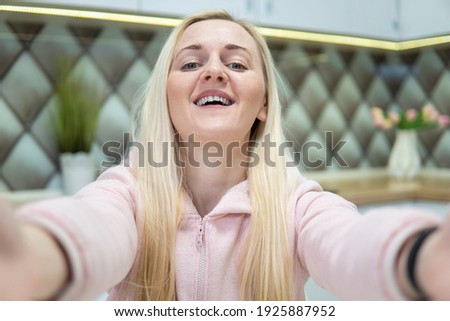 A female blogger takes a selfie on her phone.