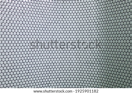 detail of a wall of round tiles on a black background in a public space