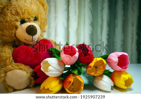 Mother's Day Teddy Bear and pink roses or other flowers e.g. tulips. It is present for mom celebrated on various days in many parts of the world, most commonly in the months of March or May