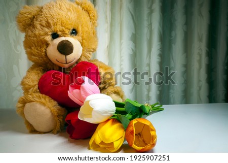 Mother's Day Teddy Bear and pink roses or other flowers e.g. tulips. It is present for mom celebrated on various days in many parts of the world, most commonly in the months of March or May