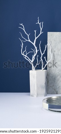 Branch and marble in front of navy background