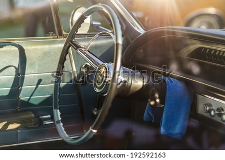 Vintage car´s chrome and blue steering wheel with lens flare