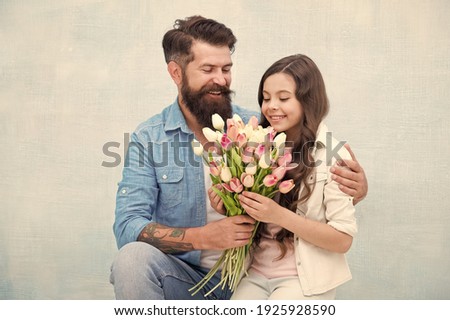 dad congratulate small girl on holiday and give flowers. family day. spending time together. daughter take tulip flower bouquet. happy father got gift on fathers day. 8 March. International Women Day.