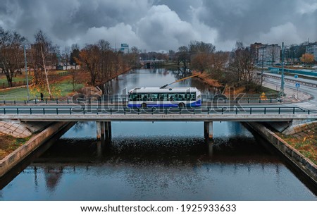 Modern city trolleybus in Riga passes through Zunds channel, Daugava river. Royalty-Free Stock Photo #1925933633