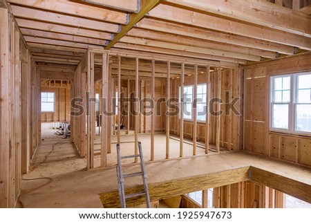 Wooden frame structure house building on a new development framing of under construction Royalty-Free Stock Photo #1925947673