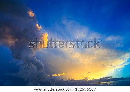 Dramatic sunset sky with yellow, blue and orange approaching thunderstorm clouds.