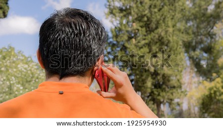 Over shoulder of a man talking on the phone outdoors