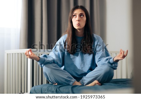 Mother in Lotus Yoga Pose Relaxing in Nursery Room. Calm mom meditating and unwinding while baby sleeps
 Royalty-Free Stock Photo #1925973365