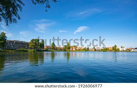 Landscape of city buildings and lake under clear blue sky