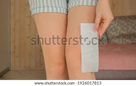 Leg waxing. Young woman waxing legs close up. Hair removal with wax at home