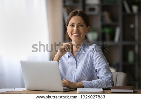 Portrait of happy millennial Caucasian businesswoman work on laptop online at home office. smiling young woman employee or worker consult client partner distant on computer. Technology concept. Royalty-Free Stock Photo #1926027863