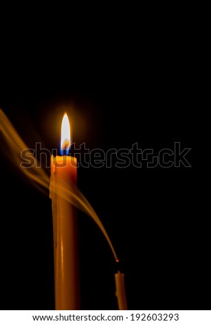 Yellow candle on the dark background