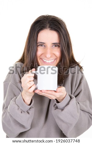 Attractive girl is holding a hot drink white mug in white background 