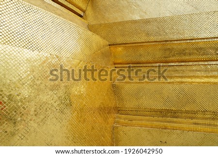 Gold tiles reflection background of retro thai culture shot from Pagoda from The Temple of the Emerald Buddha in Bangkok Thailand