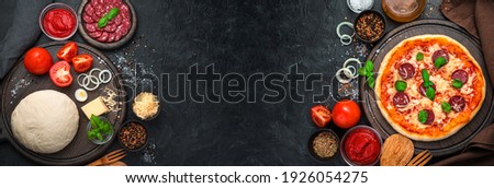 Raw ingredients and ready-made pizza on a black background. Banner with copy space, Cooking background. Royalty-Free Stock Photo #1926054275