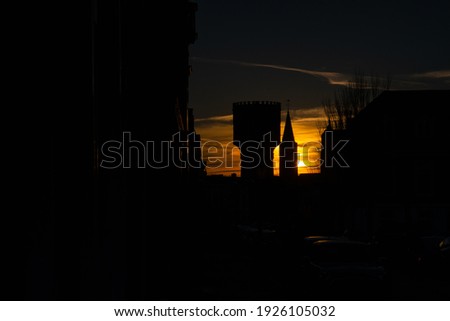 Water tower and church silhouette at warm sunset