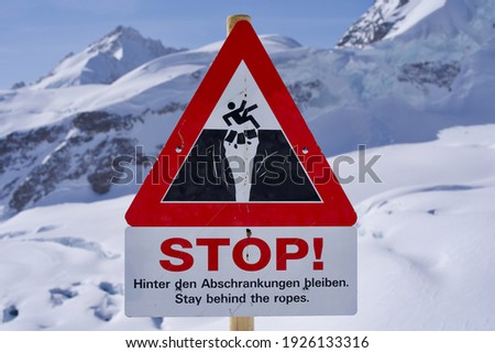 Stop sign danger of crevasses, text stay behind the ropes, Jungfraujoch, Switzerland.