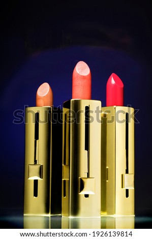 Three lipsticks on a navy blue background