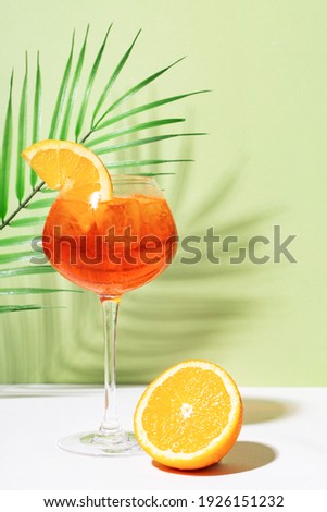 Aperol spritz on white and green background.  Hard light and shadow Royalty-Free Stock Photo #1926151232