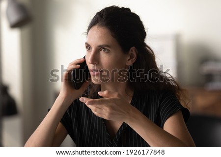 Close up head shot confident young woman holding smartphone, talking, making phone call, businesswoman consulting client, explaining, speaking, discussing project with colleague or business partner Royalty-Free Stock Photo #1926177848