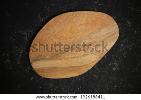 An old cutting board on a gray black background. Centered. Top view.