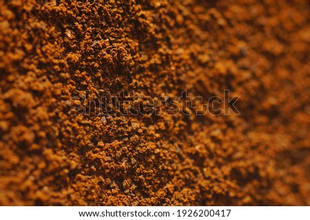 Ground coffee in macro magnification. Daylight, visible details, natural background. Blurred frame elements for promotional text.