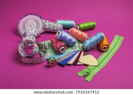Sewing kit. Colored thread on bobbins and tape measure. 