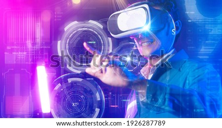 Teenager having fun play VR virtual reality glasses sport game 3D cyber space futuristic neon colorful background, future digital technology game and entertainment