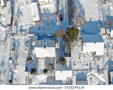 Drone image of Raasiku vilage from above.  Snowy village, lots of houses and roads. Sunny winter day. Winter village - wonderland. Cold weather. February  weather in Estonia. Small houses.