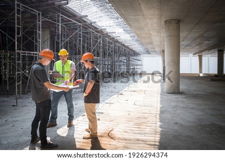 Confident team of architect working together in building construction site. They discussing about new startup project. Architect discuss with engineer about project . Architectural concept. Royalty-Free Stock Photo #1926294374