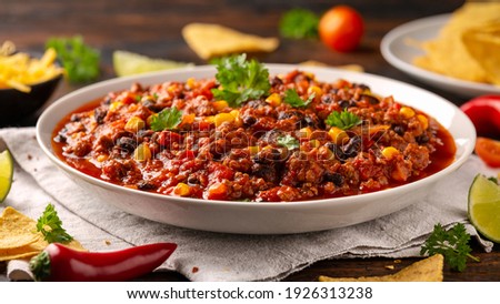 Chilli con Carne with tortilla chips and cheese in white bowl. Mexican food. Royalty-Free Stock Photo #1926313238
