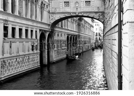 Venice, Italy. Canal with the Bridge of Sighs and a gondola. Black and white picture. Venice in monochrome.                               