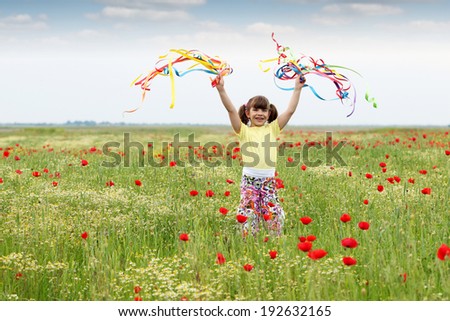 little girl with colorful ribbons on meadow