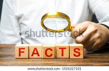 Man examines the blocks with word facts with a magnifying glass. Checking facts and data for plausibility. Debunking fakes and counter propaganda. Conspiracy, mistrust of official information sources Royalty-Free Stock Photo #1926327101