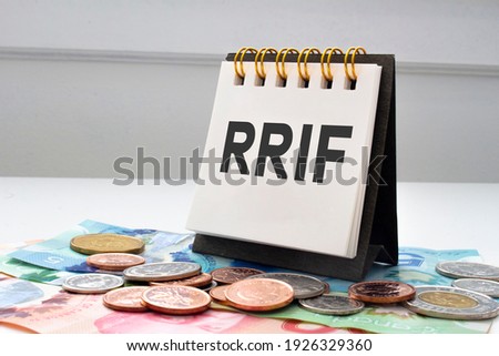 RRIF letters on notebook with coins and bills on a clear background