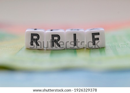 RRIF letters on white blocks with bills on a clear background