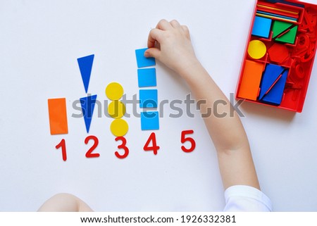 The child learns Number line and geometric shapes. The preschooler works with Montessori material. Educational logic toys for kid's. Children's hands close-up. Montessori Games for Child Development Royalty-Free Stock Photo #1926332381