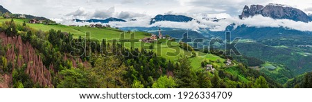 Panoramic view on natural Earth Pyramids in Renon, Ritten with medieval church and Alps on background, South Tyrol, Alto Adige, Italy. Travel destination