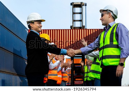 Success Team of man, woman engineer,architects checking hand after meeting,working, discussing,planing,designing, in construction site, container factory. Businessman handshake with head of engineer.