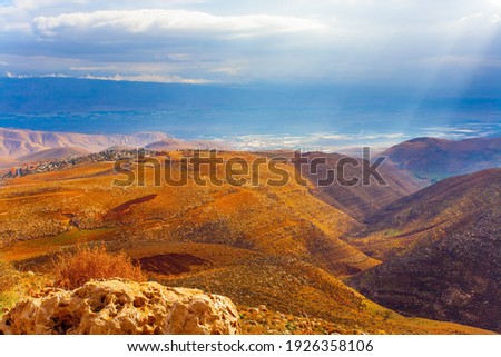 Legendary Dead Sea. Ancient terracotta-colored mountains surround the healing waters of the Dead Sea. The sun's rays illuminate the picturesque hills. Israel