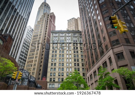 A view on Skyscrapers from Water street with cloudy sky and green trees and traffic lights