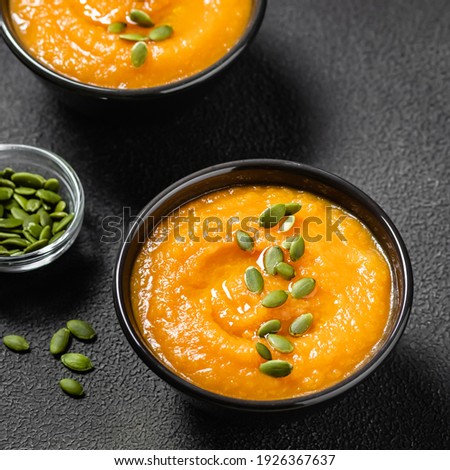 Slow cooker pumpkin soup on dark background.Space for text.